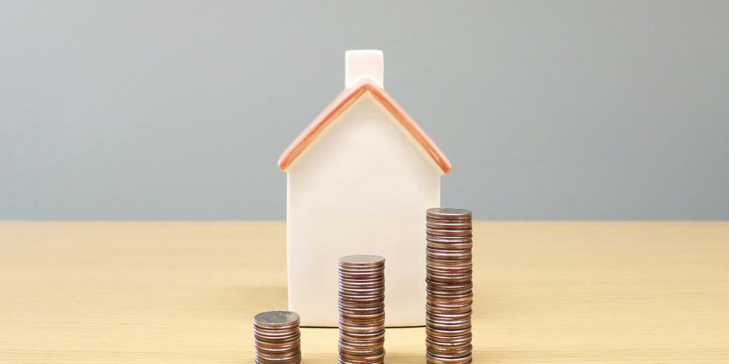 a house and stacks of coins on a table