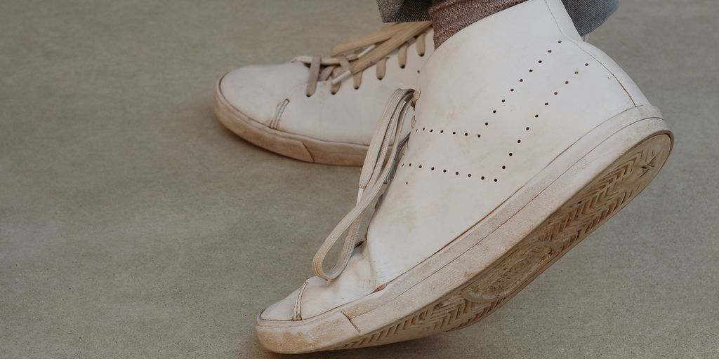 person wearing white mid-top sneakers