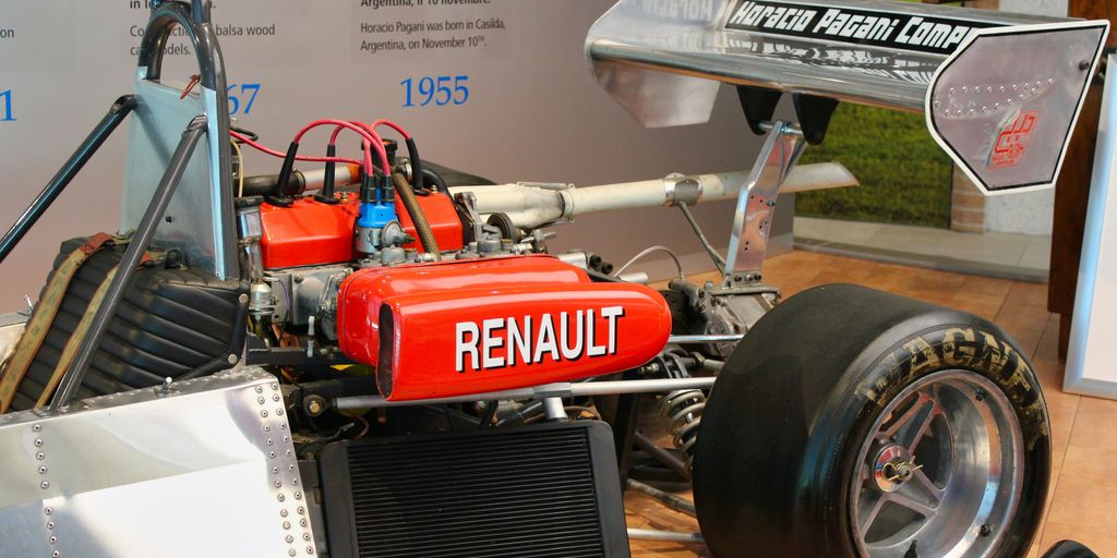 a red race car is on display in a museum
