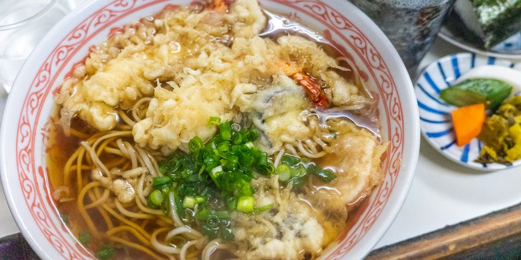 a bowl of noodles with shrimp and vegetables