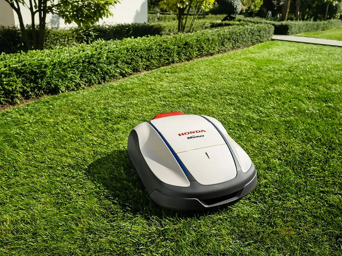A robotic lawn mower on a well-maintained green lawn.