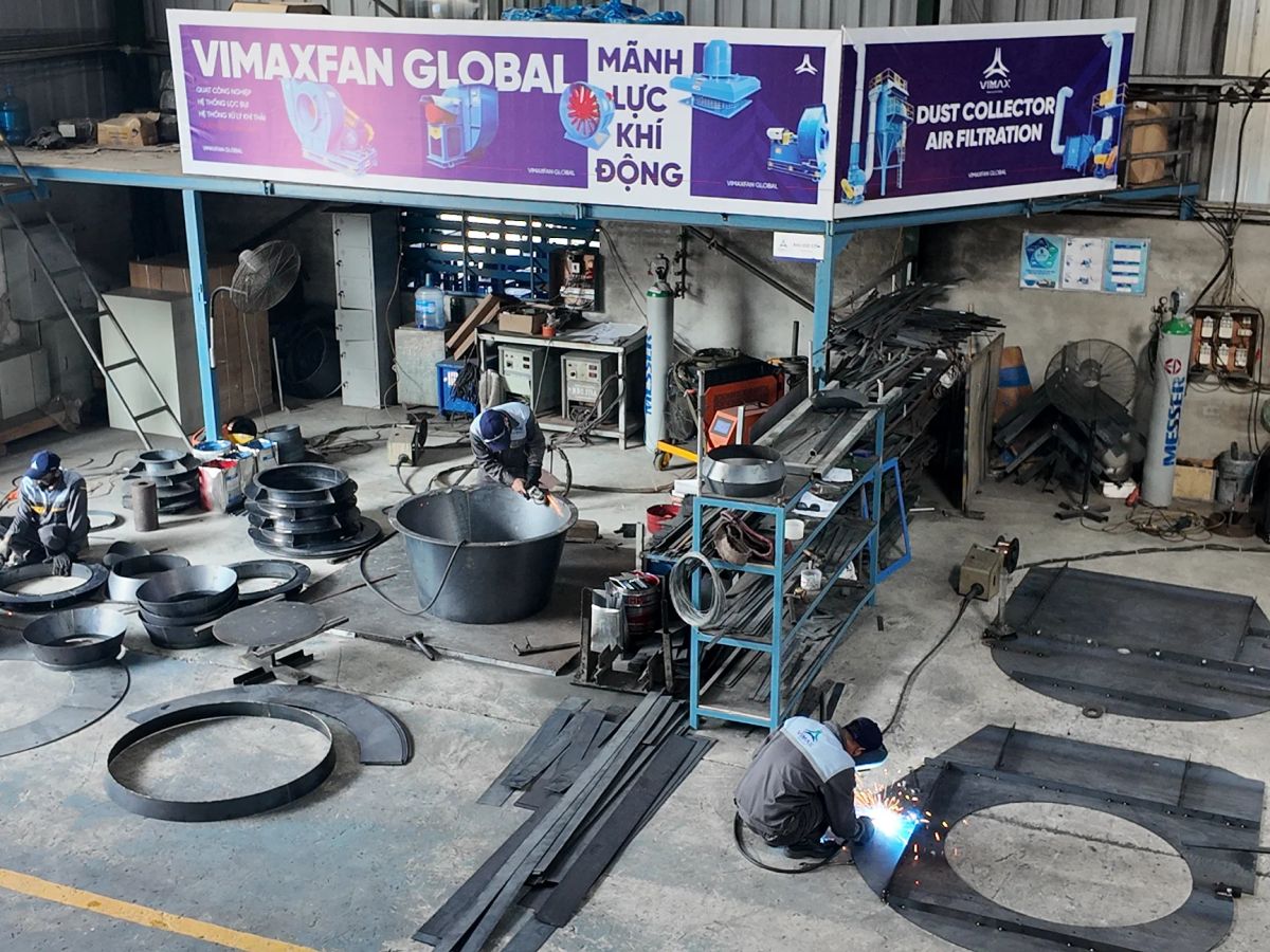 Workshop setting with workers fabricating metal parts and equipment.