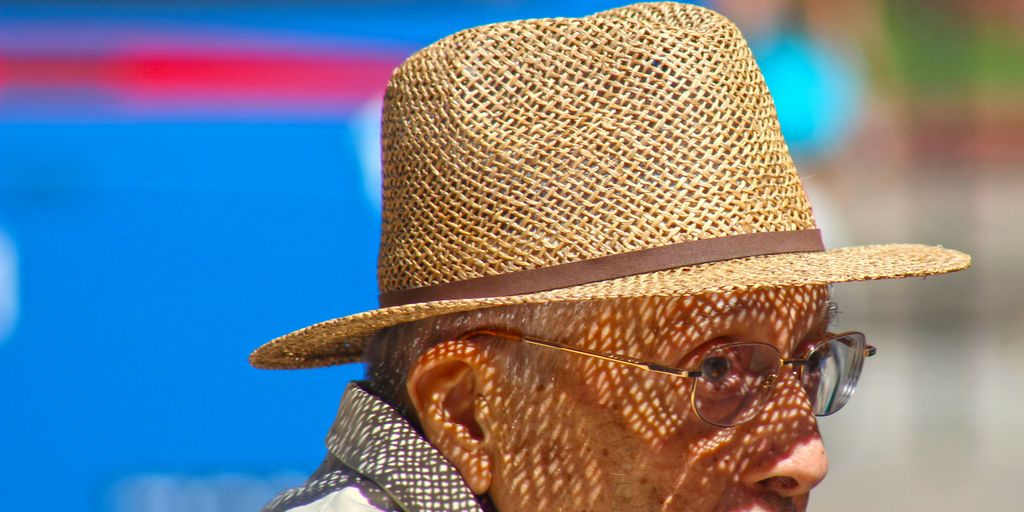 An old man wearing a straw hat and glasses