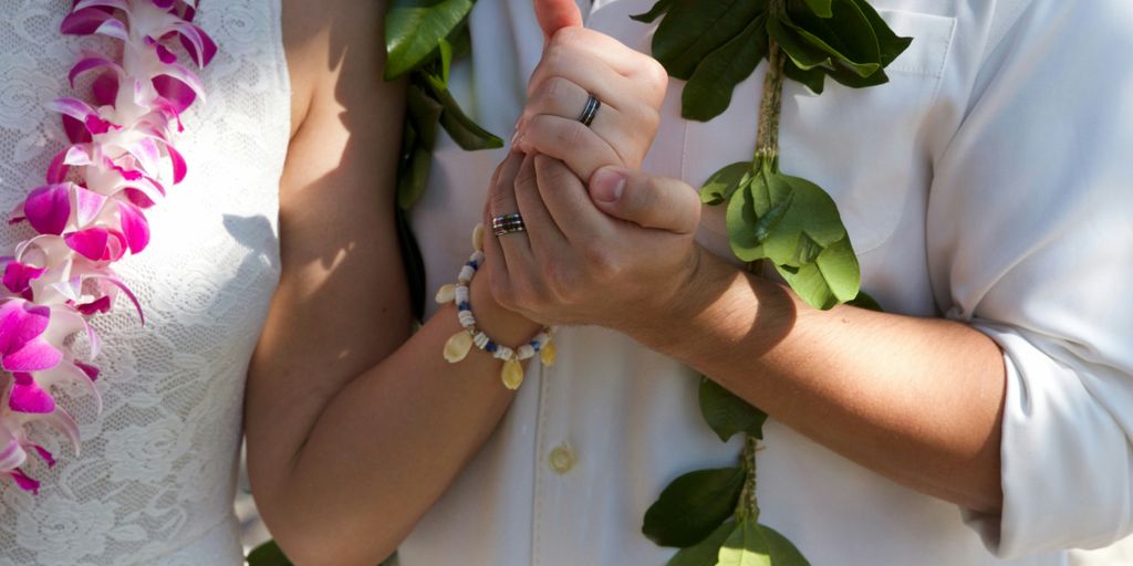 woman in white wedding dress holding green leaves