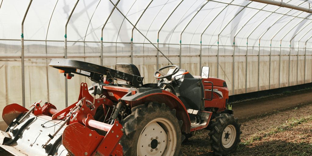 a red tractor is parked in a greenhouse