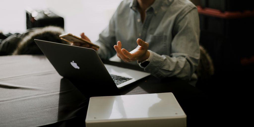 a man sitting at a table with a laptop in front of him