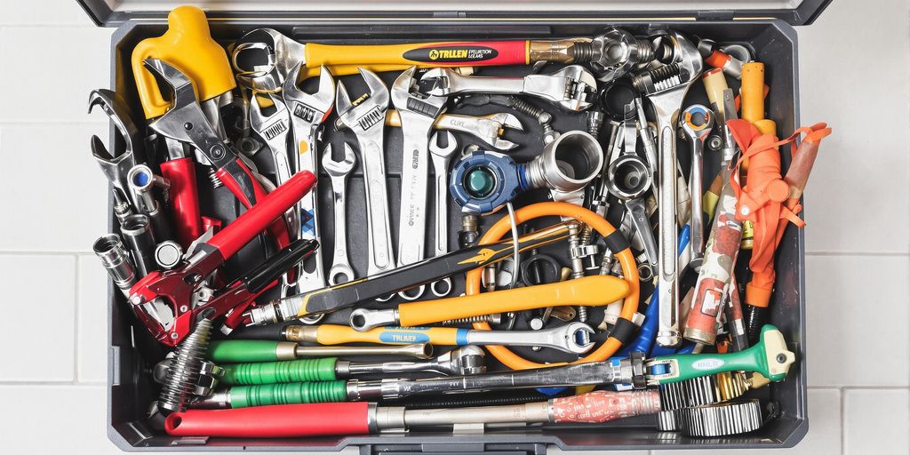 Tools for plumbing repairs including wrenches and pliers.