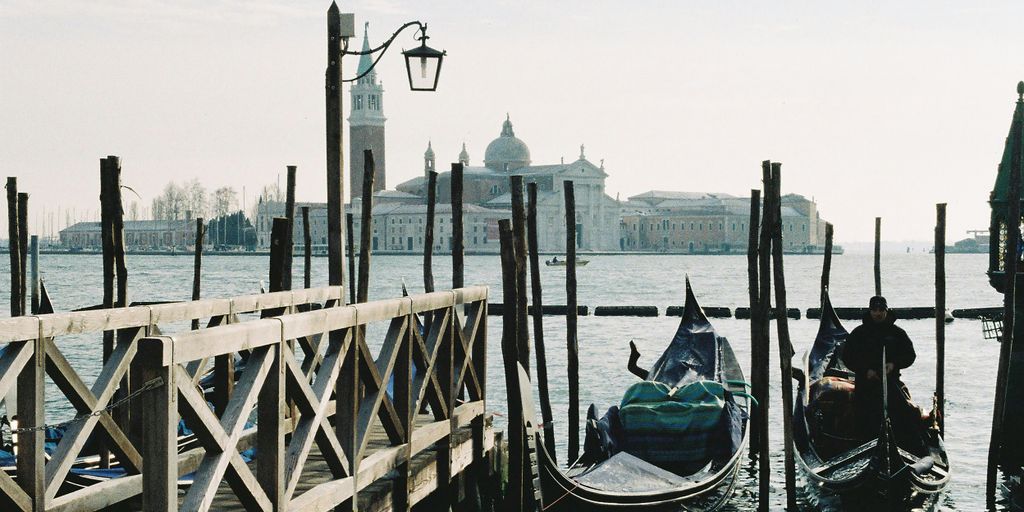 a couple of gondolas are tied to a pier