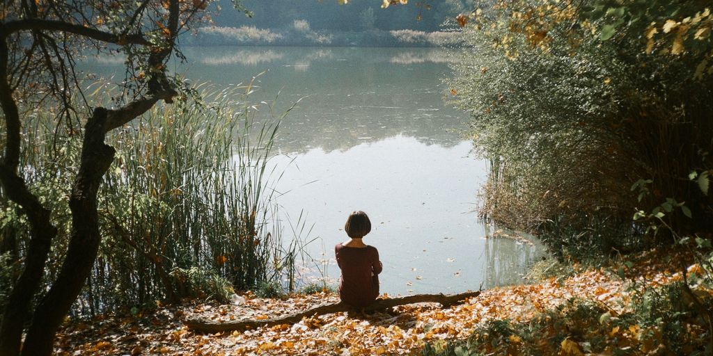 woman sitting near body of water