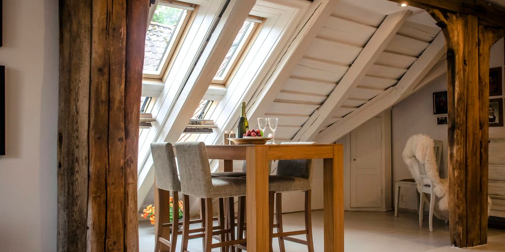 brown wooden dining table with two gray seats near opened window