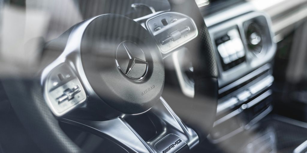 black and grey Mercedez-Benz steering wheel beside black vehicle stereo