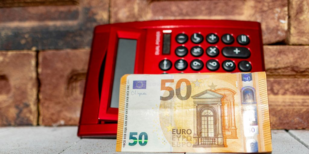 a 50 euro bill sitting next to a red telephone