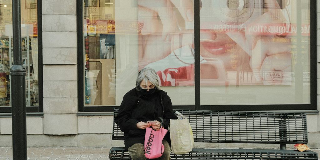 woman in black jacket and black pants sitting on bench