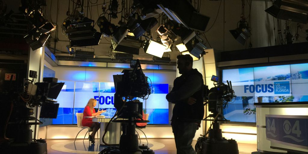 man in black suit standing on stage