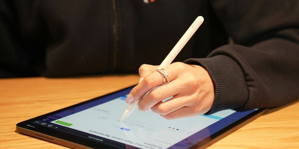a person writing on a tablet with a pen