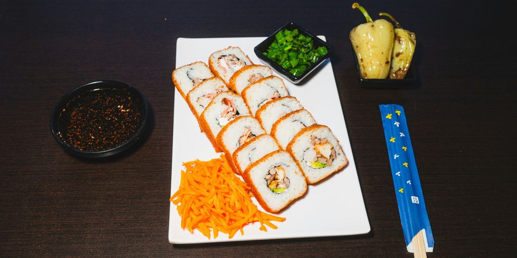 A plate of sushi and vegetables on a table