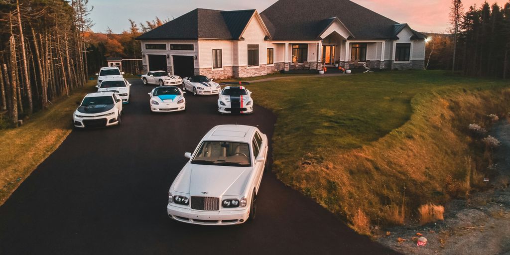 vehicles in front of white and gray house