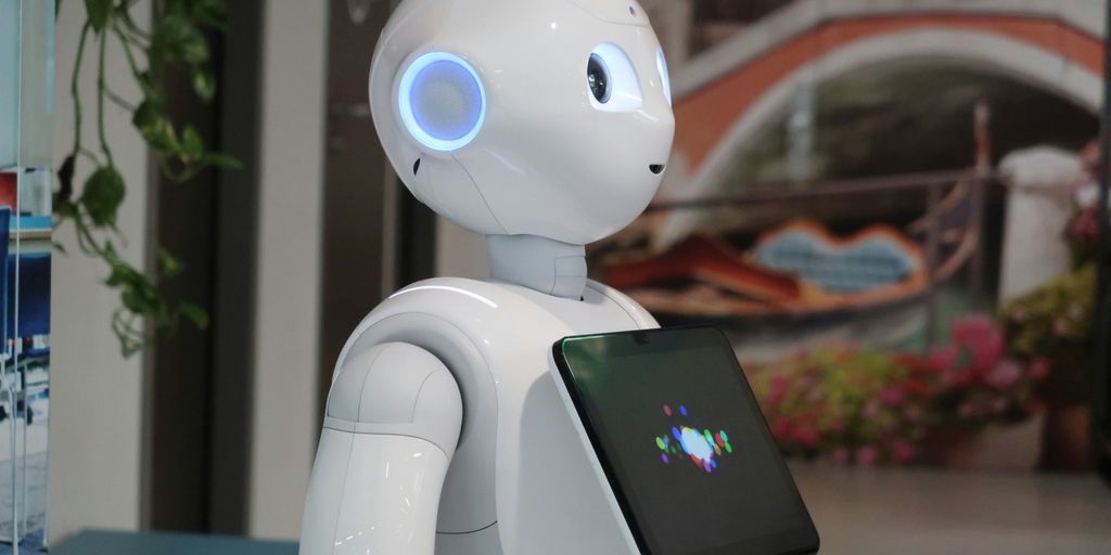 a white robot holding a tablet in its hand