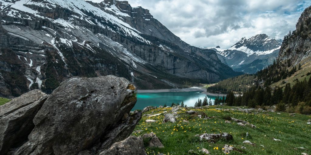 body of water surrounded by mountains during daytime