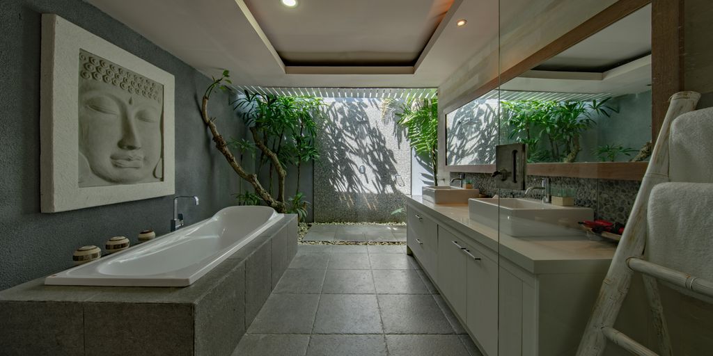 white ceramic bathtub beside gray wall