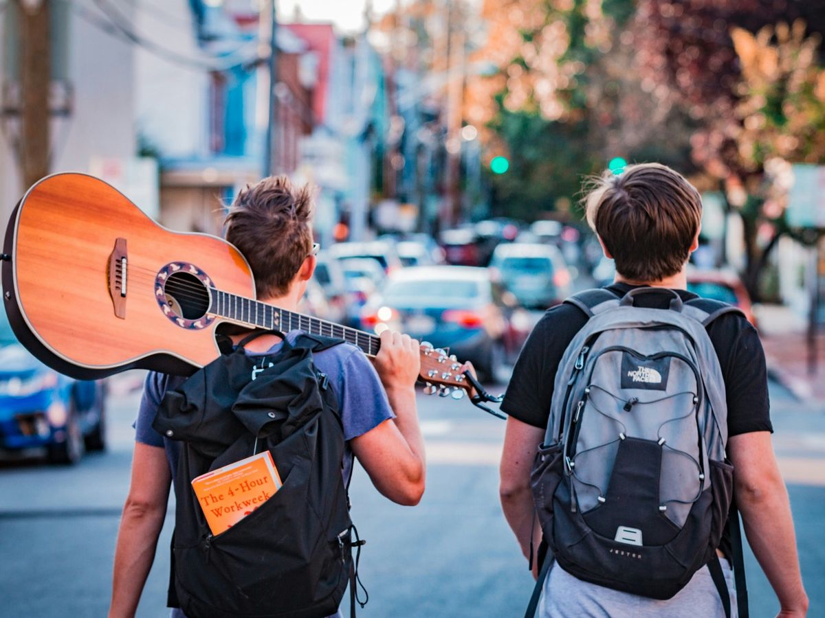 two man carrying backpacks during daytime