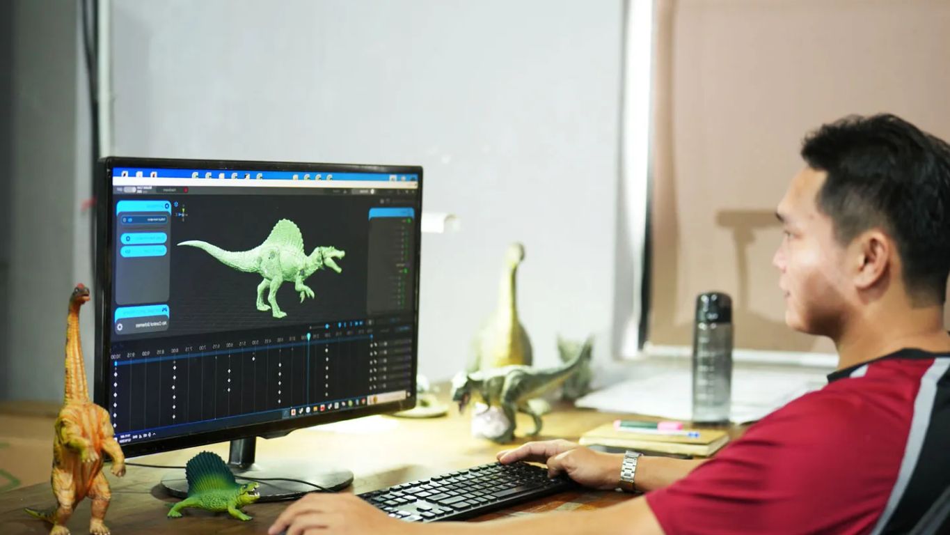 Person using a computer to create a dinosaur animation.