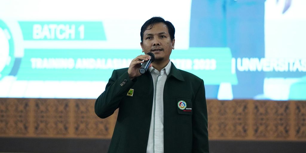 a man standing in front of a screen talking on a cell phone