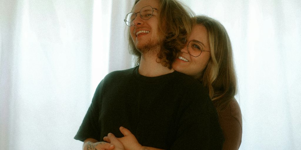 A loving couple embraces and smiles together.
