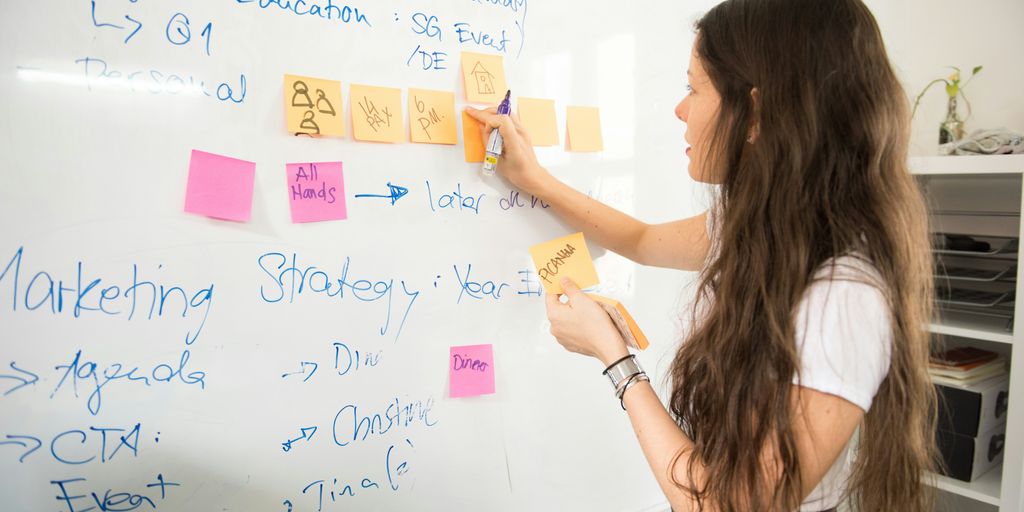 woman in blue denim jacket holding yellow sticky notes