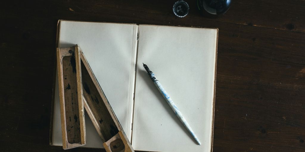 white fountain pen on white open book