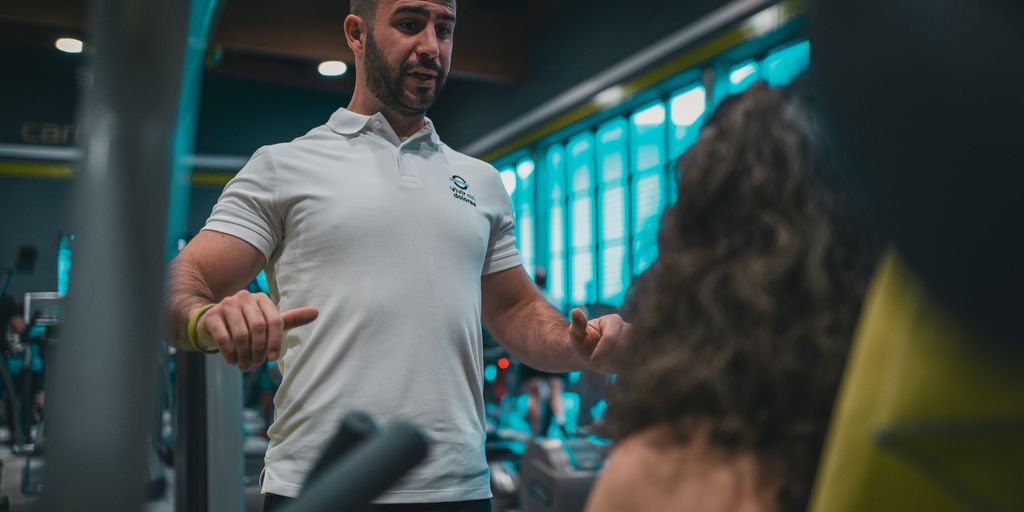 A man in a white shirt and black pants in a gym