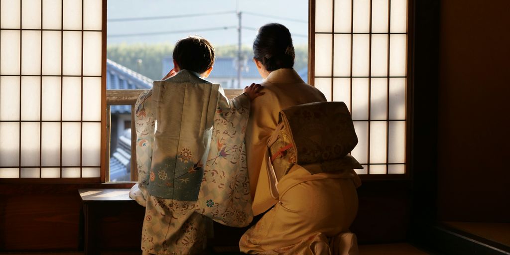 2 person sitting on chair near window during daytime