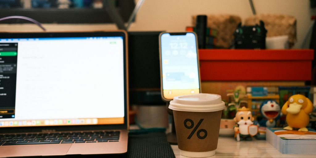 a cup of coffee sitting next to a laptop computer