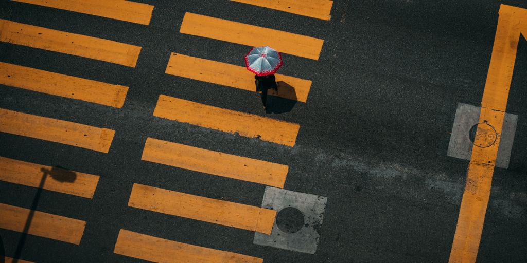 bird's-eye photography of person walking on pedestrian lane