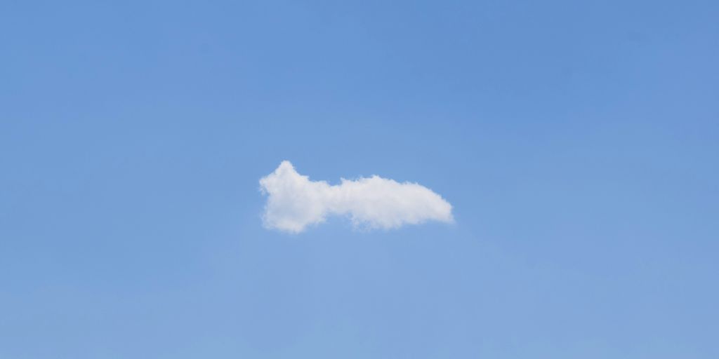 a white cloud floating in a blue sky