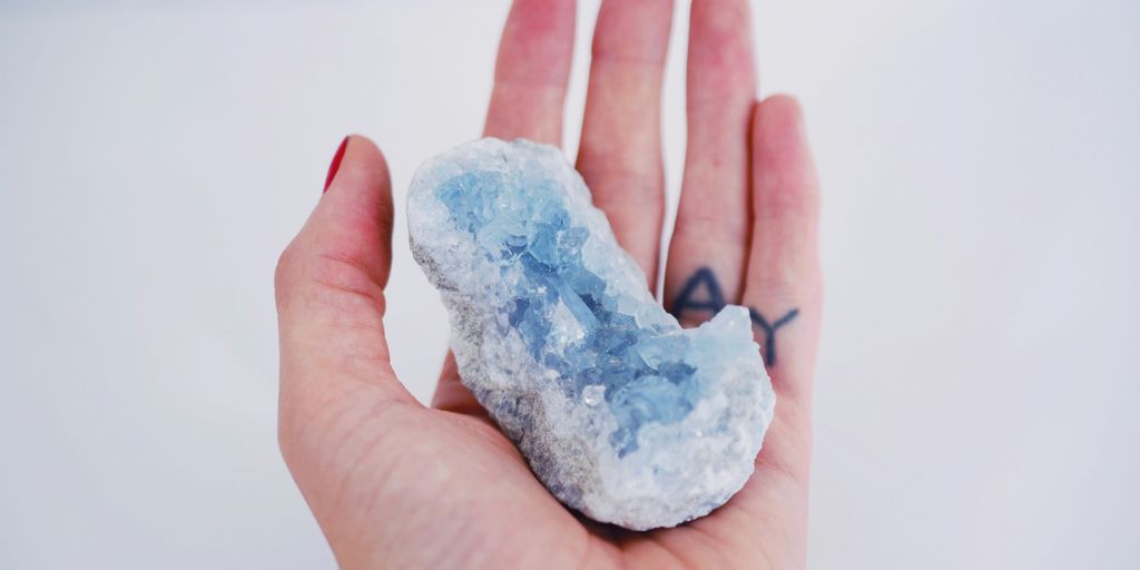a person's hand holding a small piece of ice