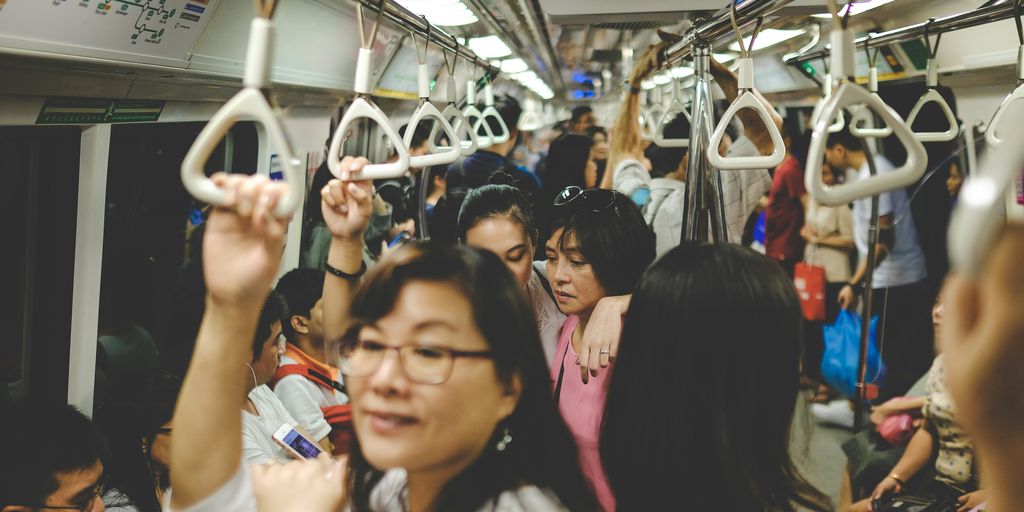 woman in pink T-shirt standing in train
