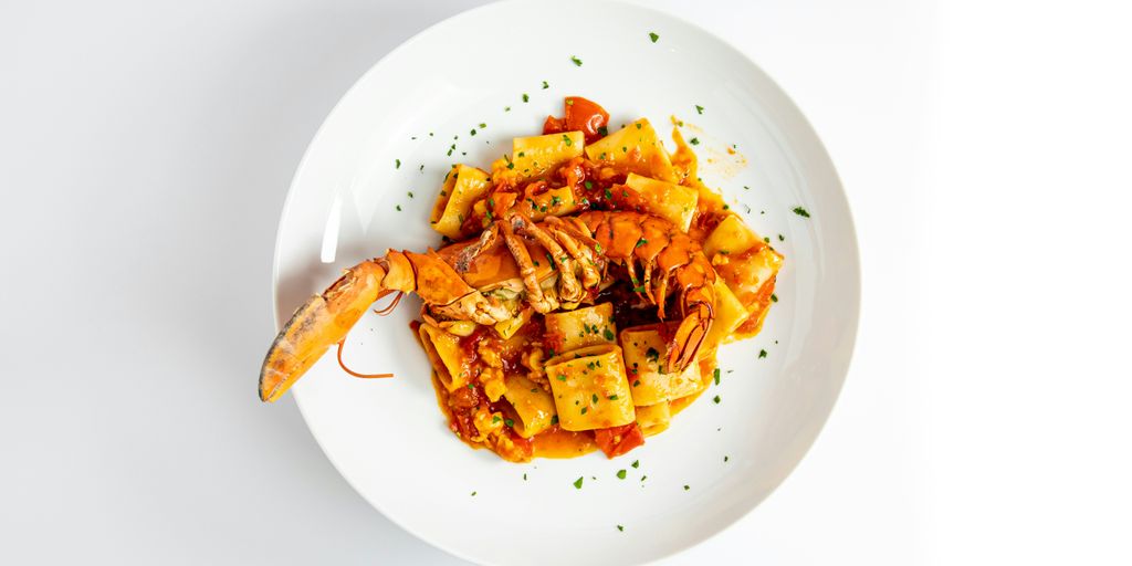 a white plate topped with pasta and shrimp