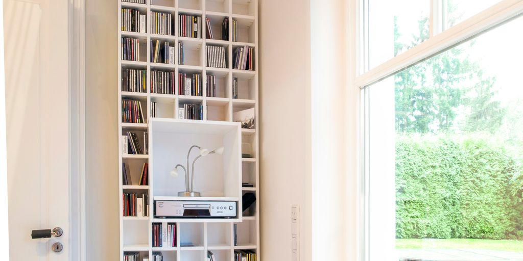 white wooden book shelf near window