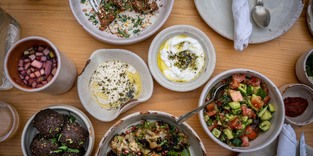 a wooden table topped with bowls of food