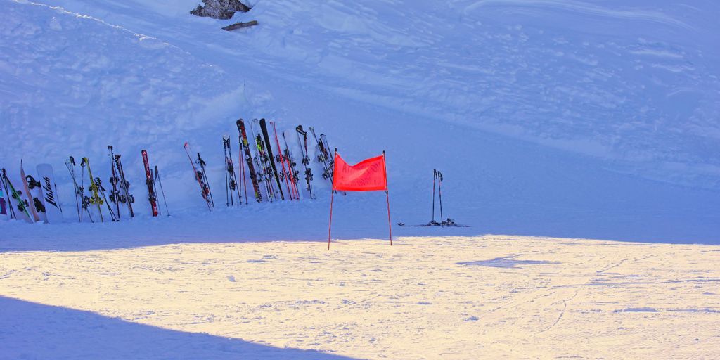 red flag on white snow covered mountain during daytime