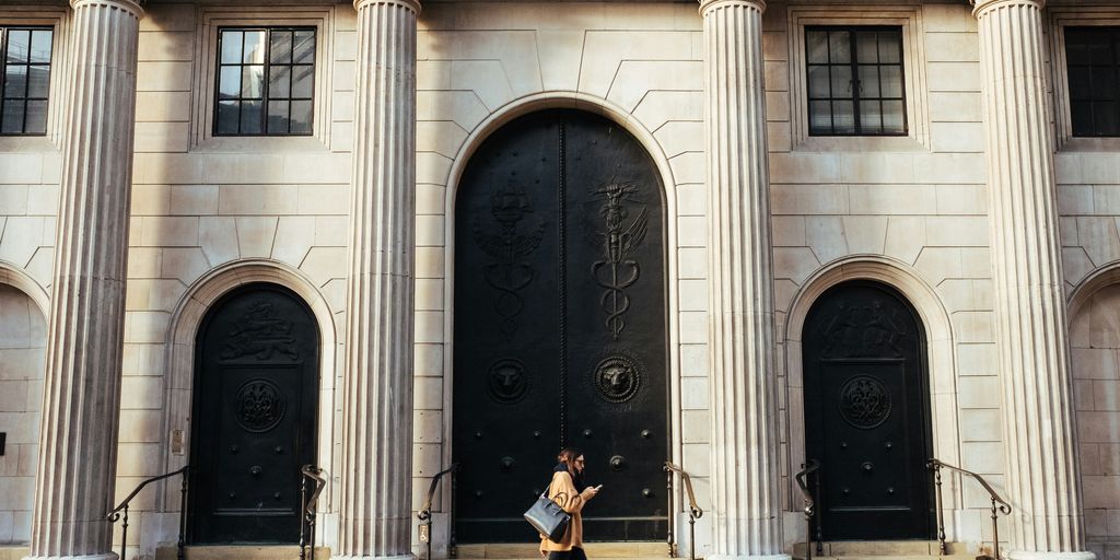 woman walking in-front of white building with ionic pillars