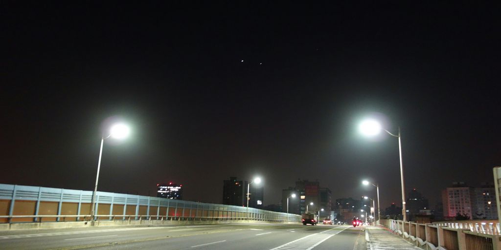 A street at night with street lights and street signs