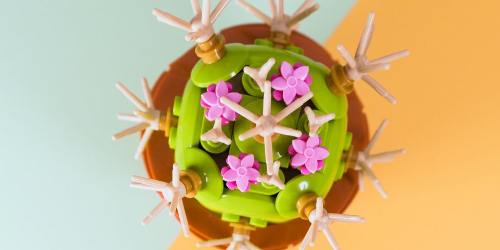 A green cake with pink flowers on top of it