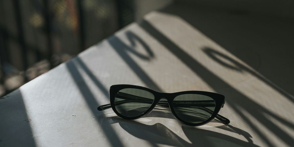 black framed sunglasses on white surface