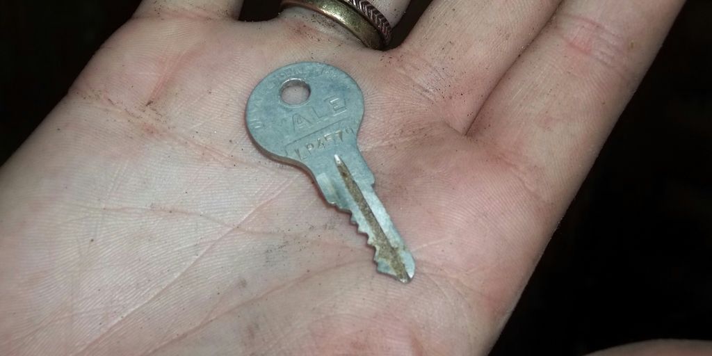gray key in person's palm