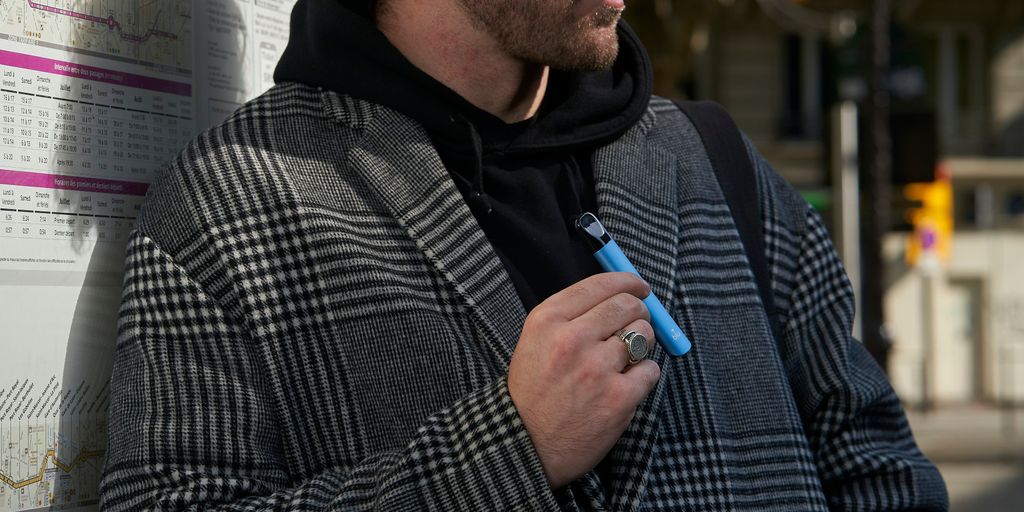 a man standing next to a wall with a pen in his hand