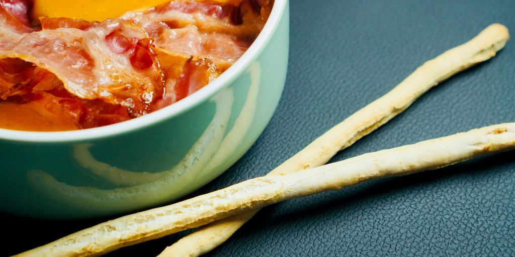 a close up of a bowl of soup and two sticks