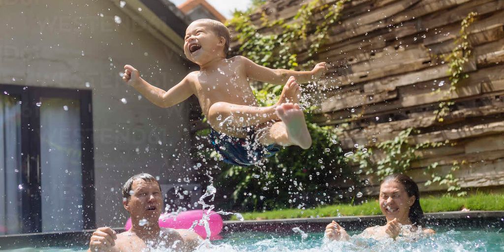 family having fun at a swimming pool in a park