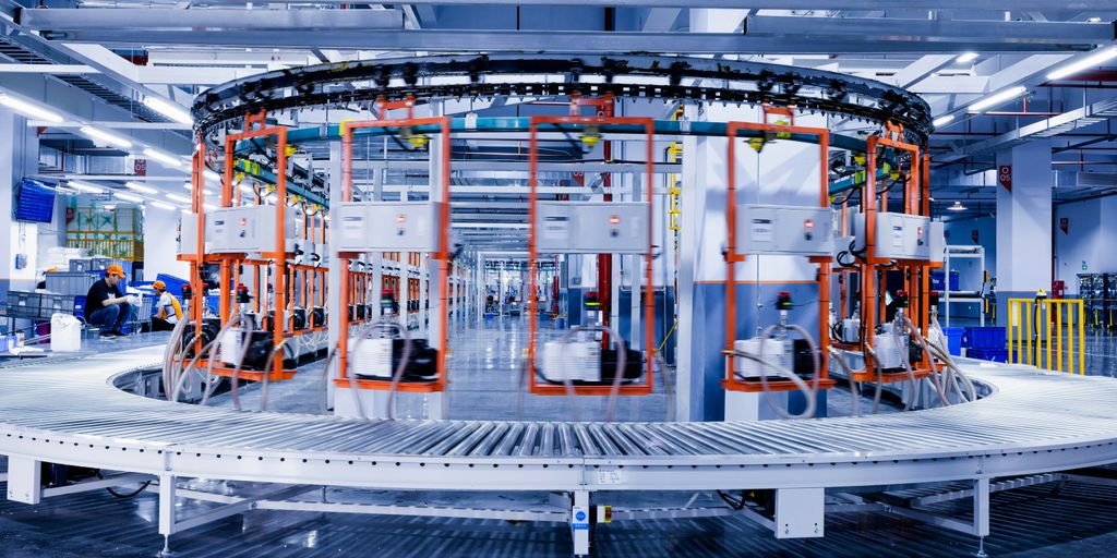 a large machine in a factory with people working on it